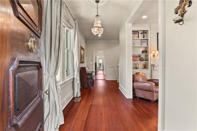 hall with ornamental molding, dark wood-type flooring, and built in features