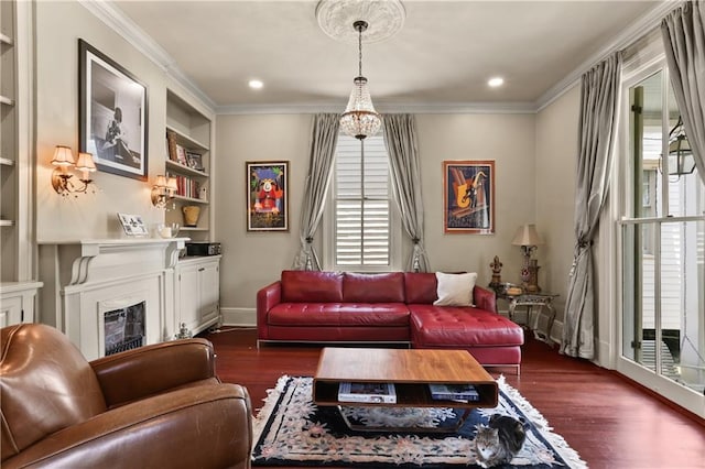 living room featuring dark hardwood / wood-style floors, built in shelves, and ornamental molding