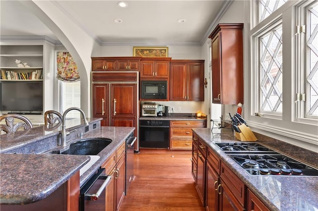 kitchen featuring sink, black appliances, wood-type flooring, and plenty of natural light