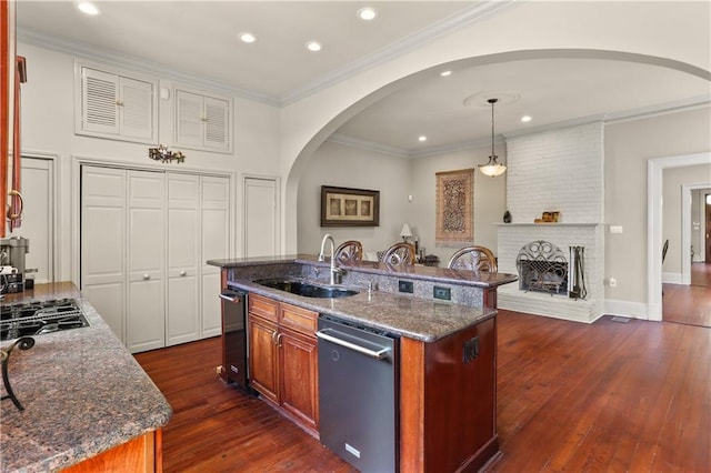 kitchen featuring dark stone counters, stainless steel dishwasher, dark hardwood / wood-style floors, and sink