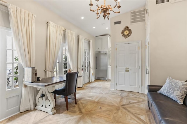 home office with a healthy amount of sunlight, a notable chandelier, light parquet flooring, and a towering ceiling