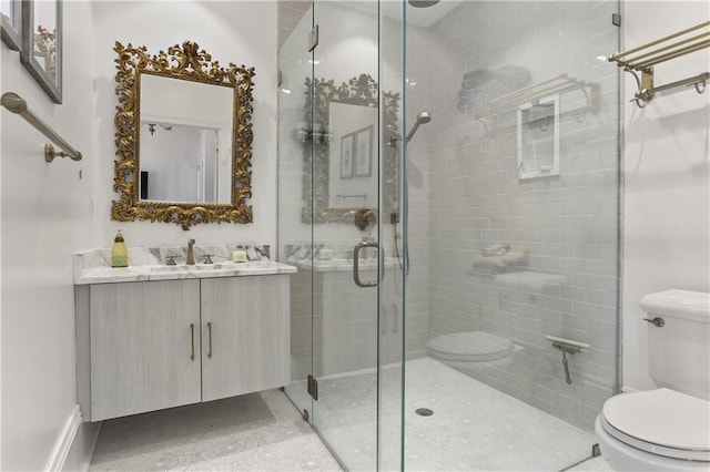 bathroom featuring tile patterned flooring, a shower with shower door, toilet, and vanity