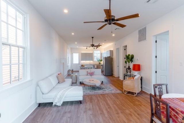 living room with light wood-type flooring and ceiling fan