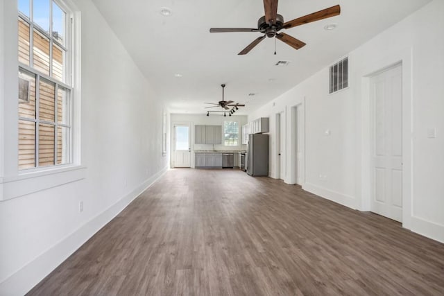 unfurnished living room with dark wood-type flooring and ceiling fan