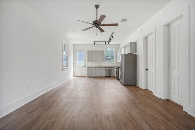 unfurnished living room featuring ceiling fan and dark hardwood / wood-style floors