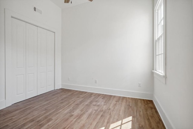 unfurnished bedroom with light hardwood / wood-style floors, a closet, and ceiling fan