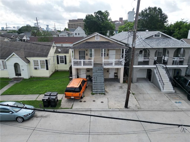 view of front of house featuring a balcony and a front lawn