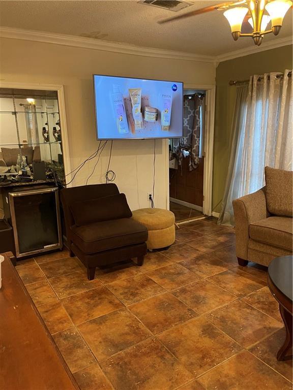 living room featuring a notable chandelier and ornamental molding