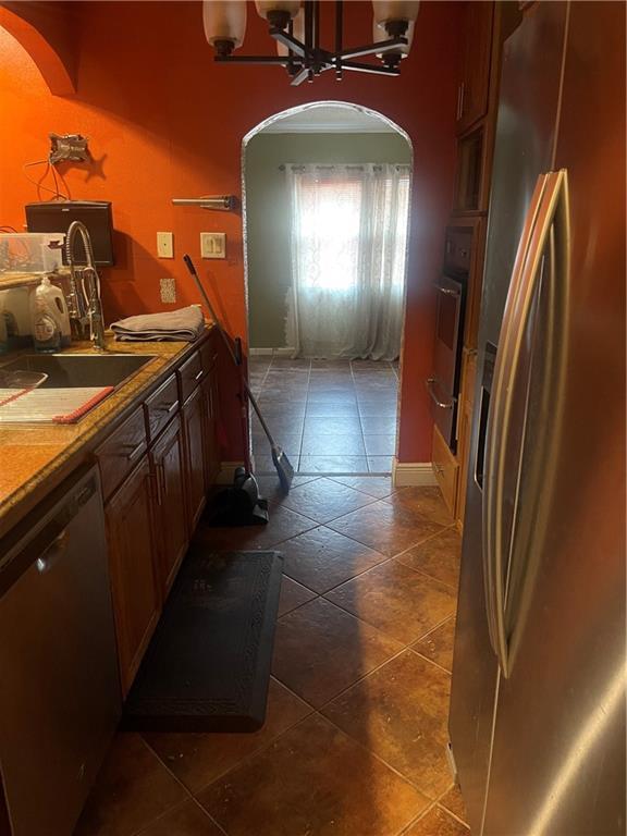 kitchen featuring stainless steel appliances, a chandelier, and sink