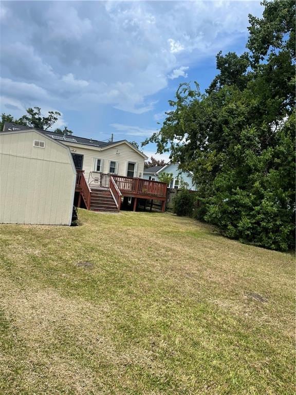 view of yard with a wooden deck and a storage unit