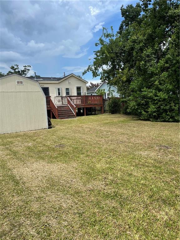 view of yard featuring a wooden deck and a shed