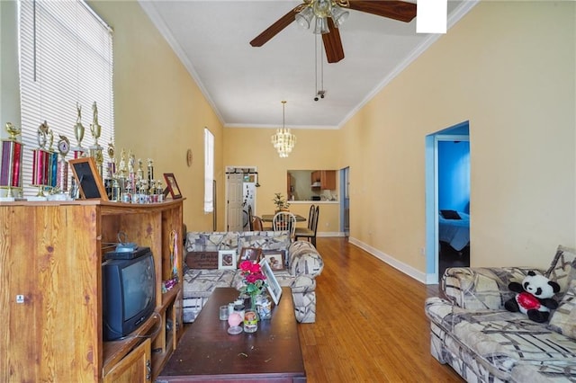 living room with ornamental molding, ceiling fan with notable chandelier, and hardwood / wood-style floors