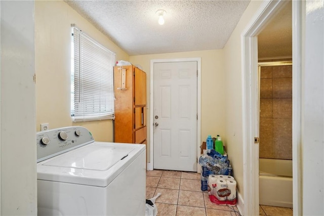 clothes washing area with washer / clothes dryer, a textured ceiling, and light tile patterned floors