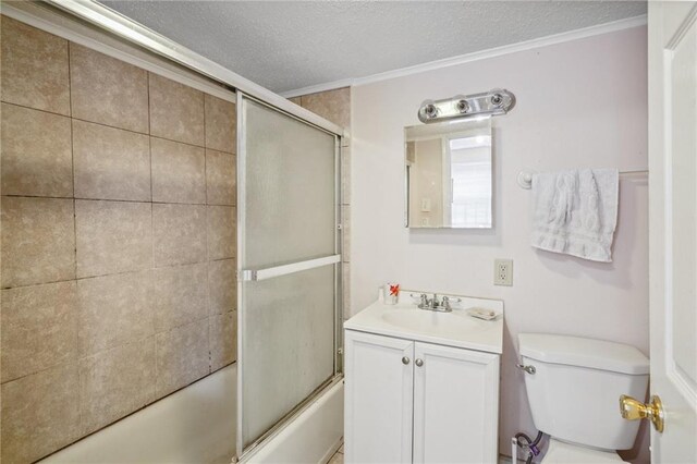 full bathroom with vanity, a textured ceiling, bath / shower combo with glass door, crown molding, and toilet