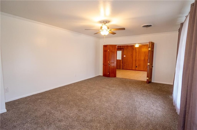 carpeted empty room featuring ornamental molding and ceiling fan