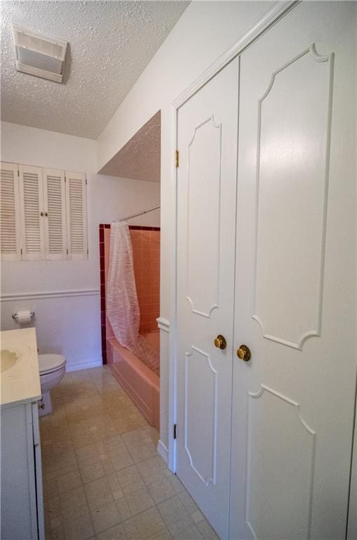 full bathroom with a textured ceiling, vanity, toilet, and shower / bathtub combination with curtain