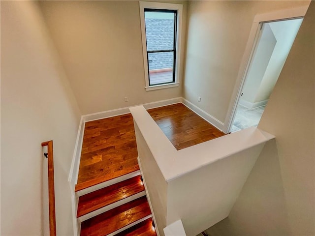 stairs with wood finished floors and baseboards