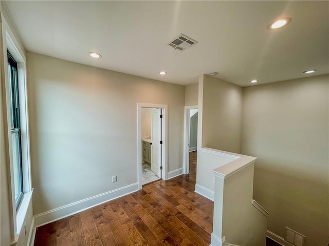 unfurnished room featuring plenty of natural light and wood-type flooring