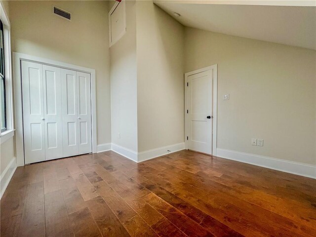 entrance foyer with hardwood / wood-style flooring and high vaulted ceiling