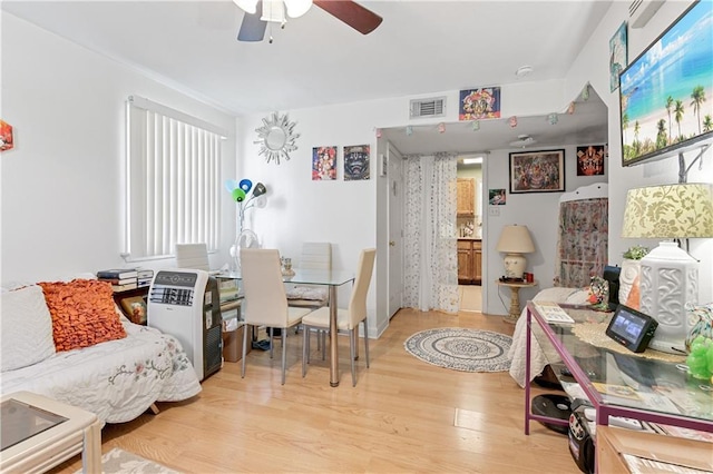 dining room featuring heating unit, ceiling fan, and light hardwood / wood-style flooring