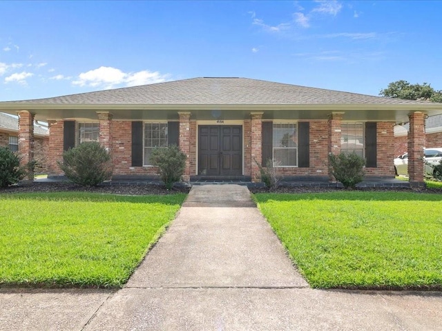 ranch-style home featuring a porch and a front lawn