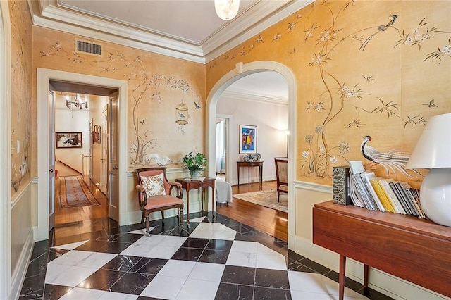 hallway featuring ornamental molding and an inviting chandelier