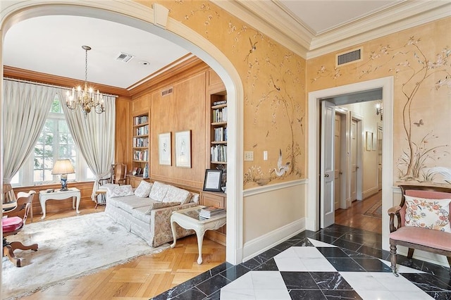 living area with a chandelier and ornamental molding