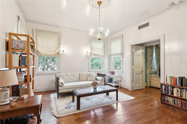 sitting room featuring a healthy amount of sunlight, crown molding, wood-type flooring, and a notable chandelier