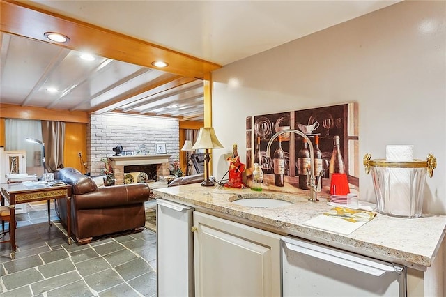 interior space featuring white dishwasher, a fireplace, and sink