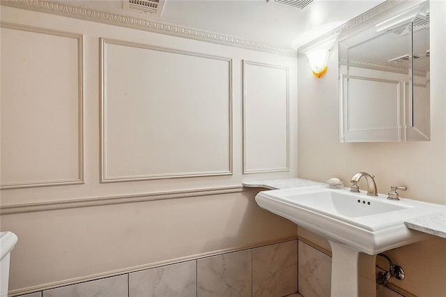 bathroom featuring crown molding and sink