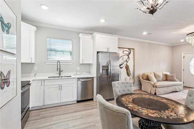 kitchen with sink, appliances with stainless steel finishes, light hardwood / wood-style floors, and white cabinetry