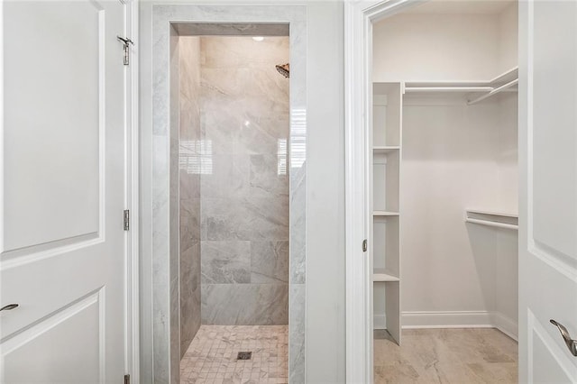 bathroom with tiled shower and tile patterned floors