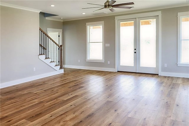 unfurnished living room featuring ceiling fan, french doors, hardwood / wood-style flooring, and ornamental molding