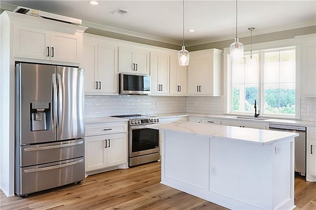 kitchen featuring white cabinets, stainless steel appliances, and light hardwood / wood-style flooring