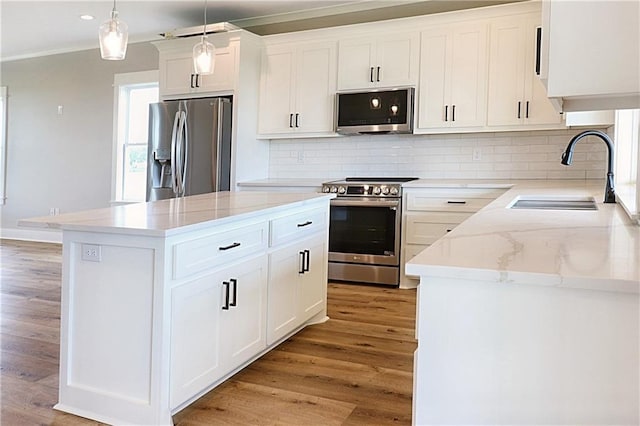 kitchen featuring sink, hanging light fixtures, stainless steel appliances, and backsplash