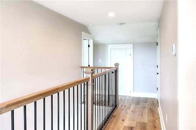 hall featuring light hardwood / wood-style flooring and vaulted ceiling