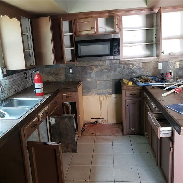 117 Larry St, Lafayette, LA 70506 - kitchen featuring backsplash, stainless steel microwave, a healthy amount of sunlight, and a sink