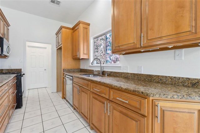 kitchen featuring light tile patterned flooring, sink, stainless steel appliances, and stone countertops