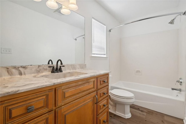 full bathroom featuring toilet, bathing tub / shower combination, hardwood / wood-style floors, and vanity