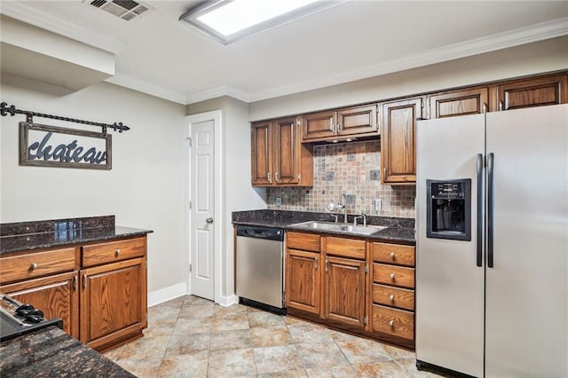 4716 Annunciation St Unit 1B, New Orleans, LA 70115 - kitchen featuring stainless steel appliances, ornamental molding, backsplash, baseboards, and brown cabinets