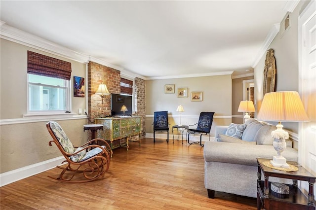 living room featuring baseboards, wood finished floors, and crown molding