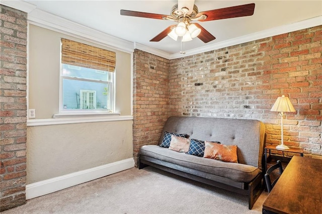 living area with baseboards, a ceiling fan, brick wall, ornamental molding, and carpet