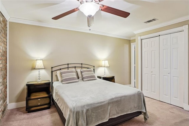 carpeted bedroom with ornamental molding, a closet, visible vents, and a ceiling fan