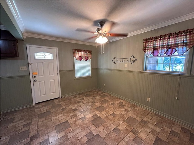 entryway featuring wooden walls, crown molding, and a wealth of natural light