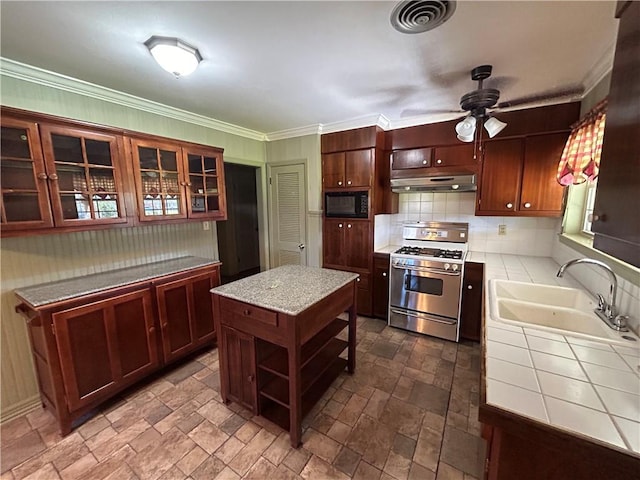 kitchen featuring gas range, black microwave, ceiling fan, sink, and a kitchen island