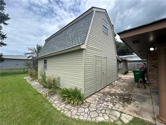 view of side of property featuring a lawn and a patio area