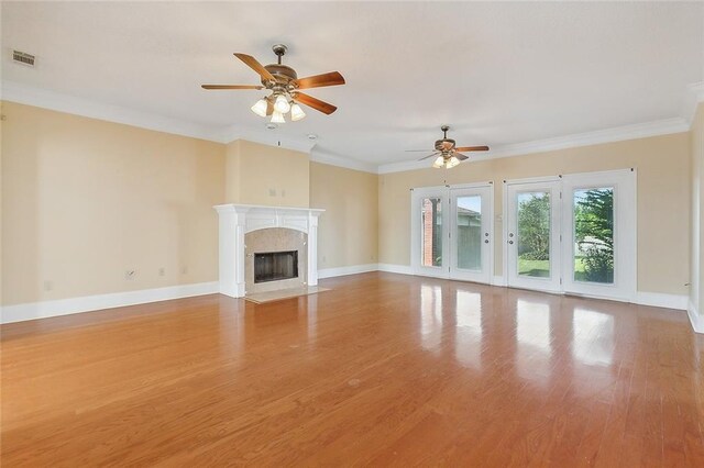 unfurnished living room featuring wood-type flooring, a high end fireplace, and ceiling fan