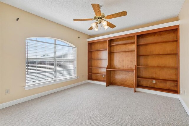 spare room featuring light colored carpet, a textured ceiling, and ceiling fan