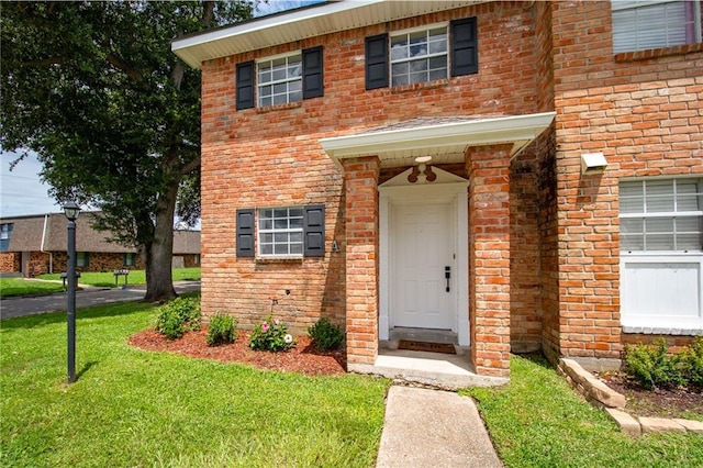 view of exterior entry featuring a yard