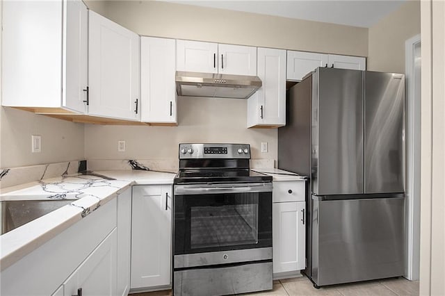 kitchen featuring light stone counters, white cabinetry, light tile patterned floors, and stainless steel appliances